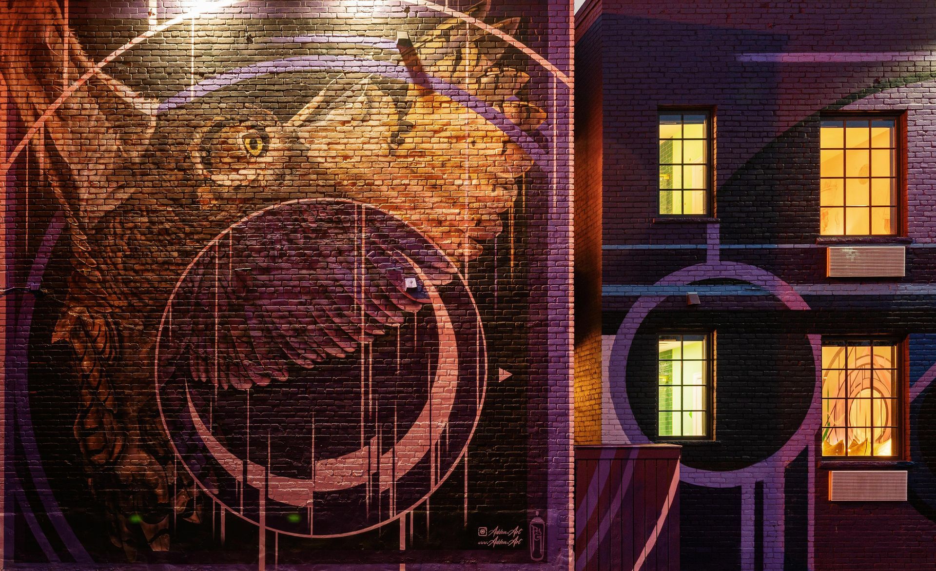 Abstract neon city scene with glowing circular patterns and lit windows in purple and orange tones