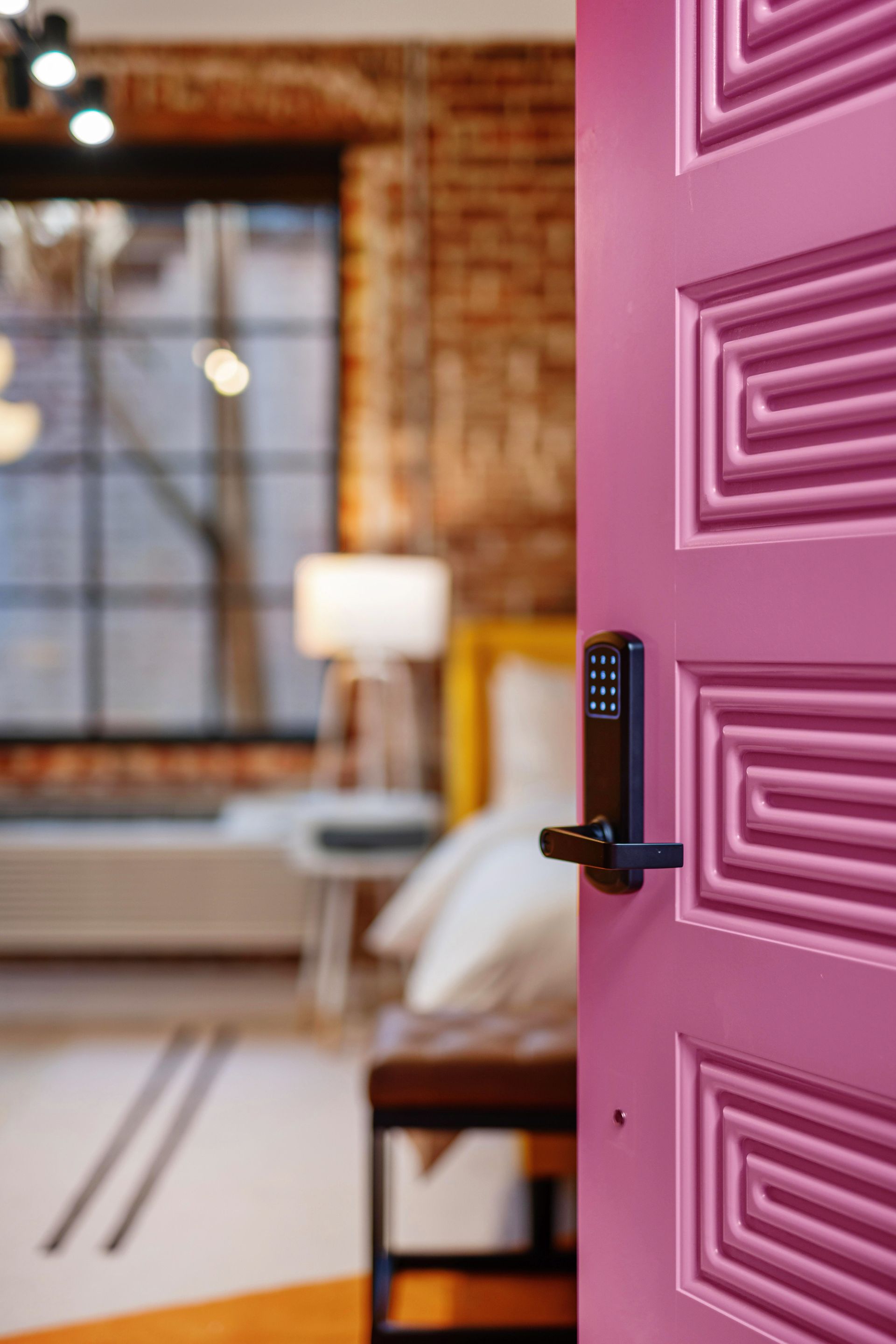 Open pink door with keypad lock in a modern loft interior