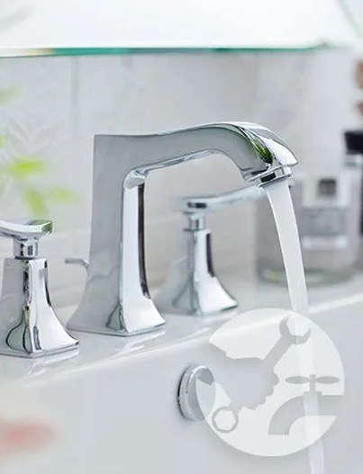 Shiny chrome bathroom faucet with water running, close-up.