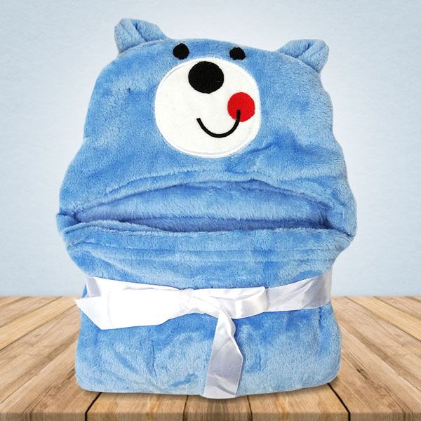 Op een houten tafel ligt een blauwe deken met een berengezicht erop.