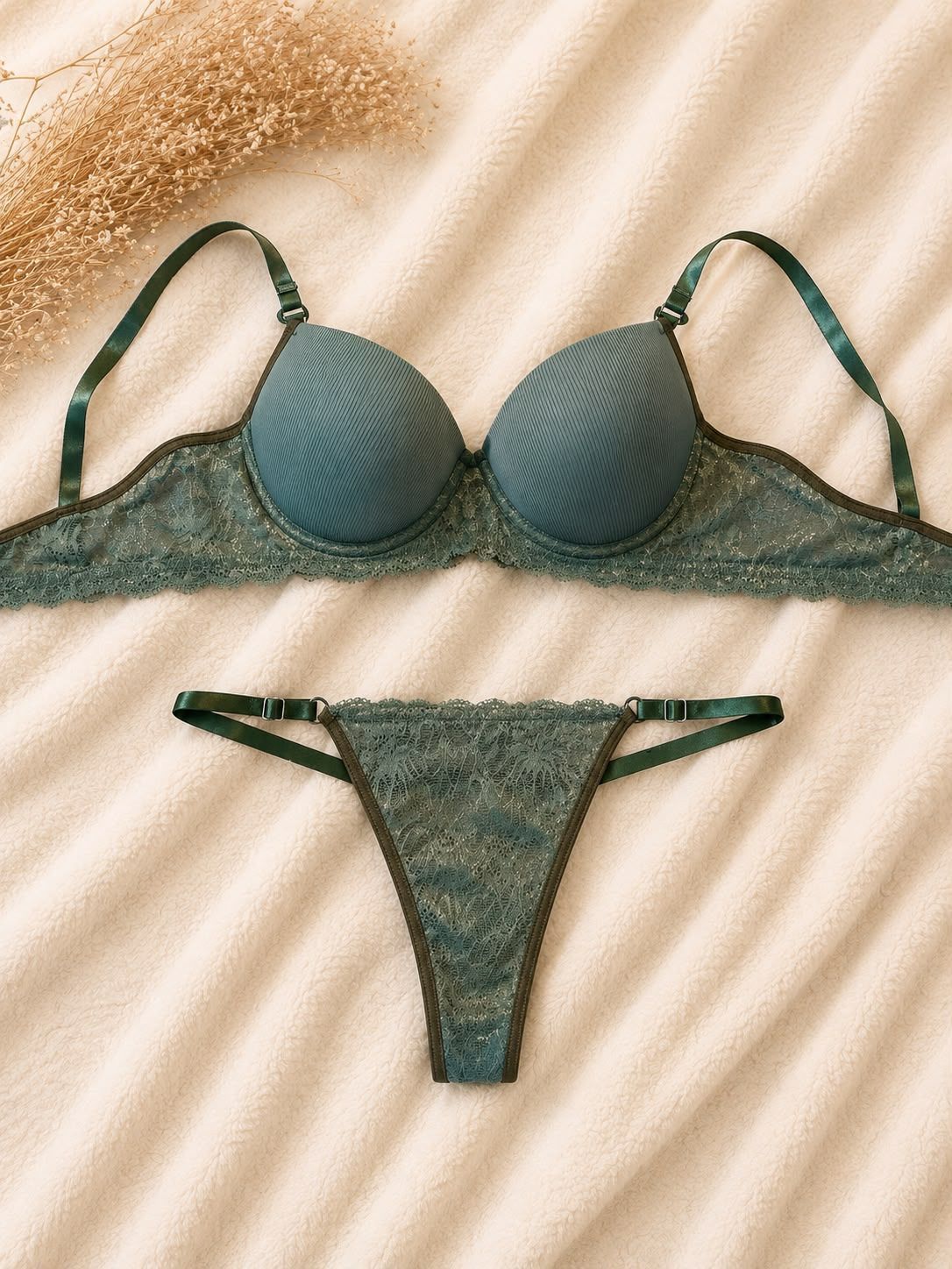 Conjunto de bikini verde sobre tela beige con un pequeño sombrero de paja.