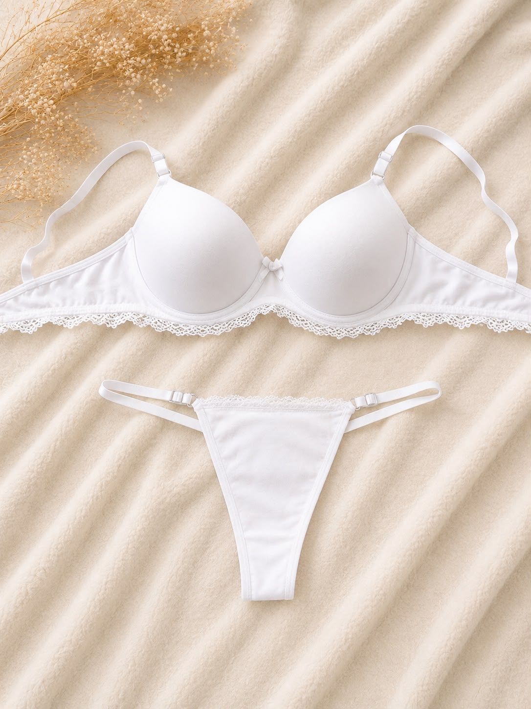 Conjunto de lencería beige, sujetador y tanga, confeccionado en tejido satinado con suaves pliegues drapeados.