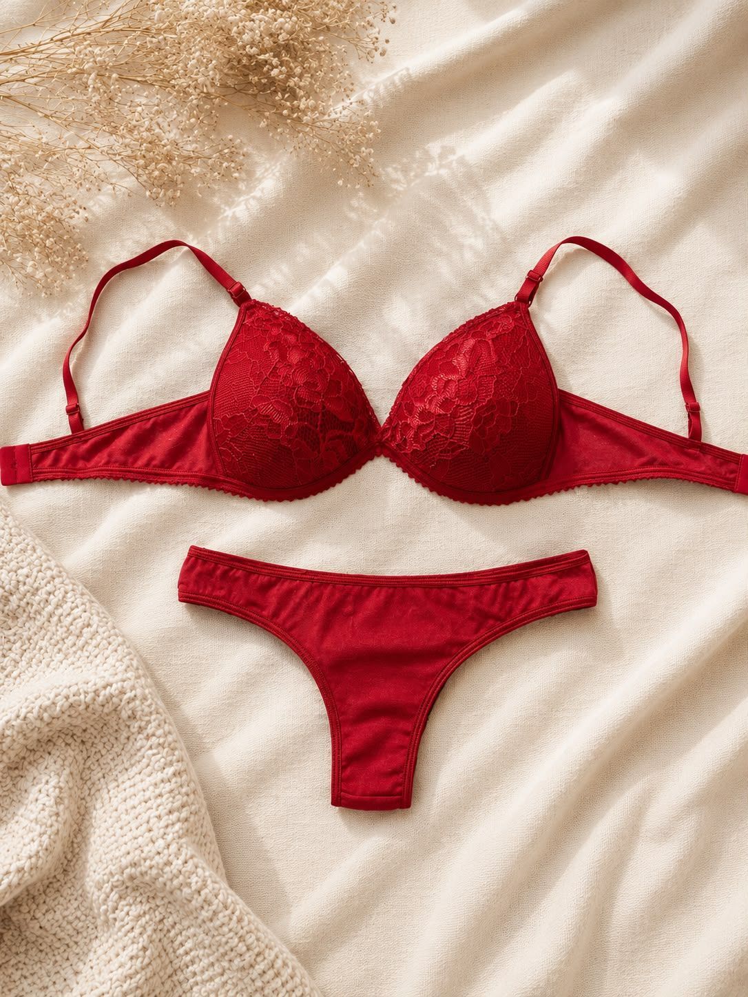 Conjunto de bikini rojo extendido sobre un fondo de tela texturizada color crema.