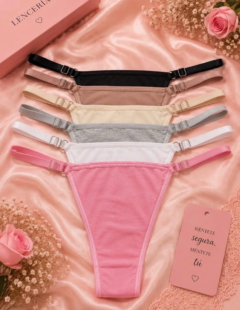 Cinco bragas de mujer en negro, color carne, plateado, blanco y rosa sobre un fondo de satén rosa.