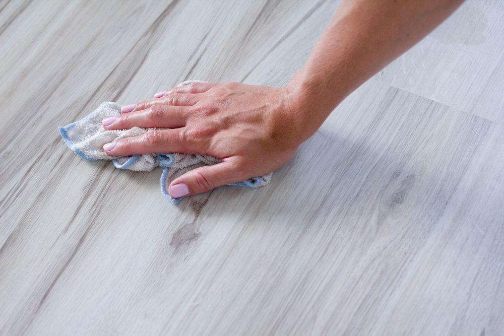 A Woman is Cleaning a Floor With a Cloth — Dawsons Cleaning Specialist In Mount Louisa, QLD