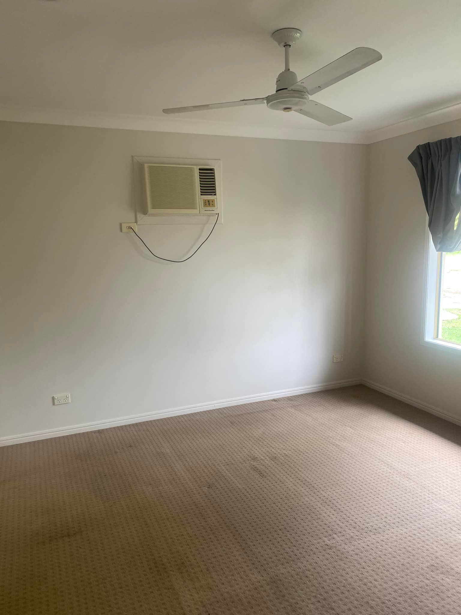 An Empty Room With a Ceiling Fan and a Window — Dawsons Cleaning Specialist In Mount Louisa, QLD