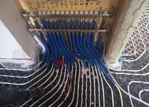 Cavi blu e bianchi collegati a una morsettiera elettrica montata a parete.
