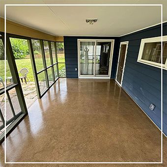 Covered porch with blue siding, tan floor, and large screened windows overlooking a green yard