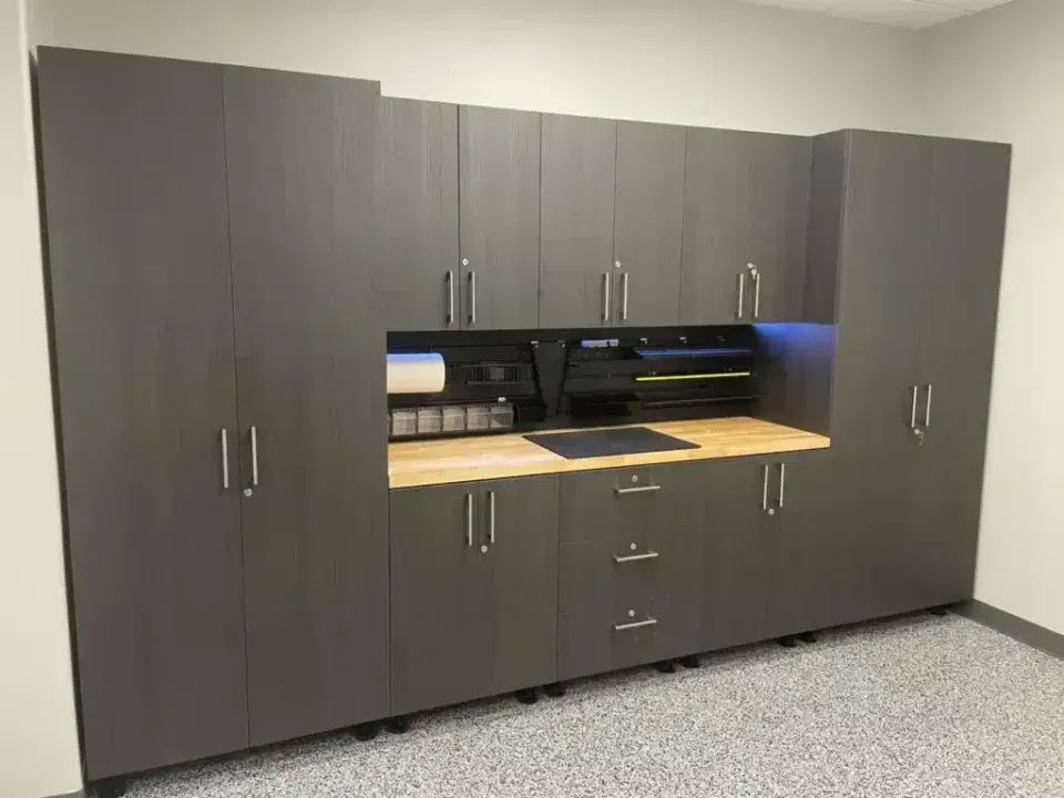 Dark wood office storage cabinets with a built-in desk and drawers against a beige wall