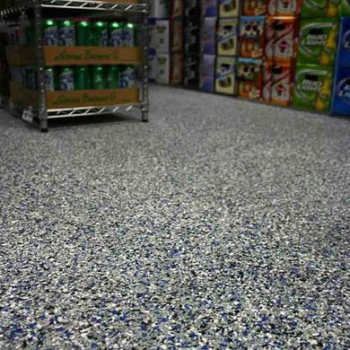 A store aisle with stacked soda bottles and colorful beverage boxes on shelves.