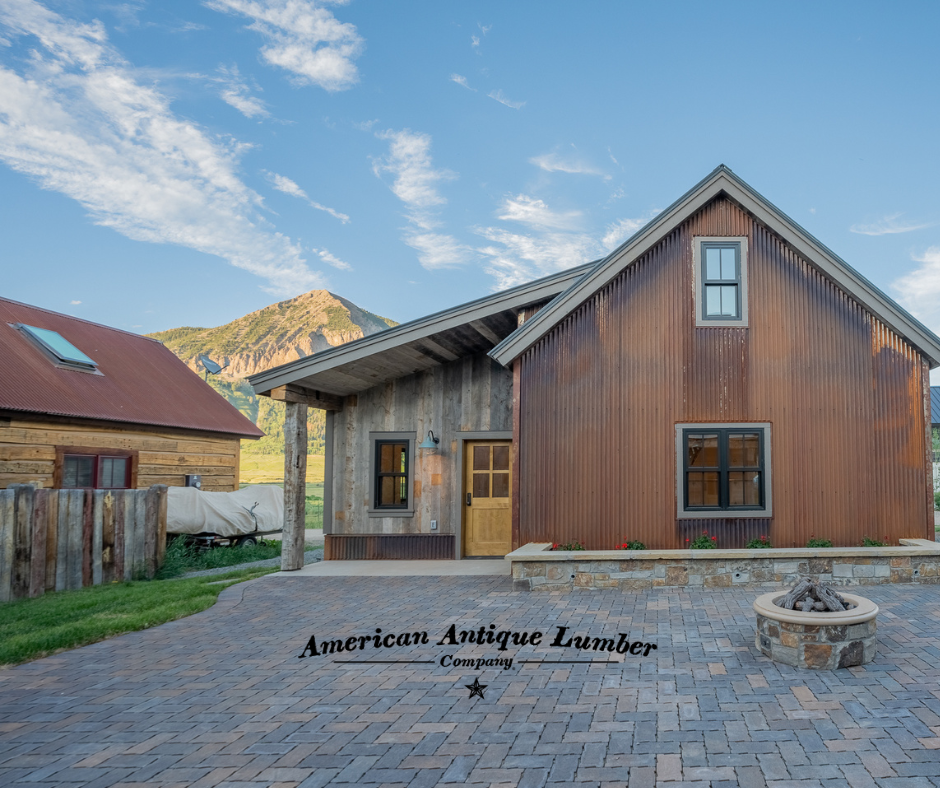 Outdoor stone firepit with vertical corrugated metal siding, vertical wood siding and Mt. Crested Butte Colorado in the sunshine.