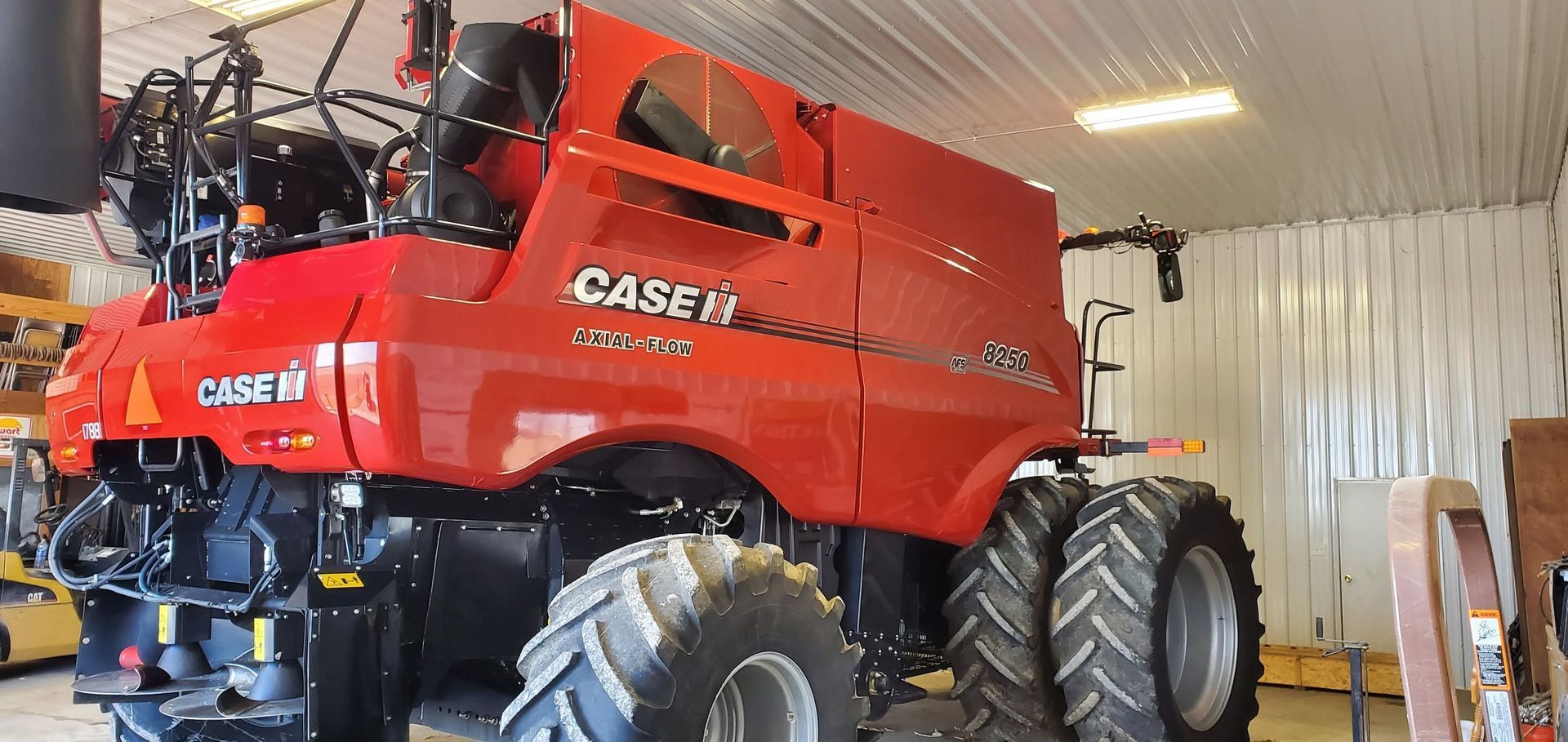 Red CASE IH combine harvester parked inside a garage or workshop.