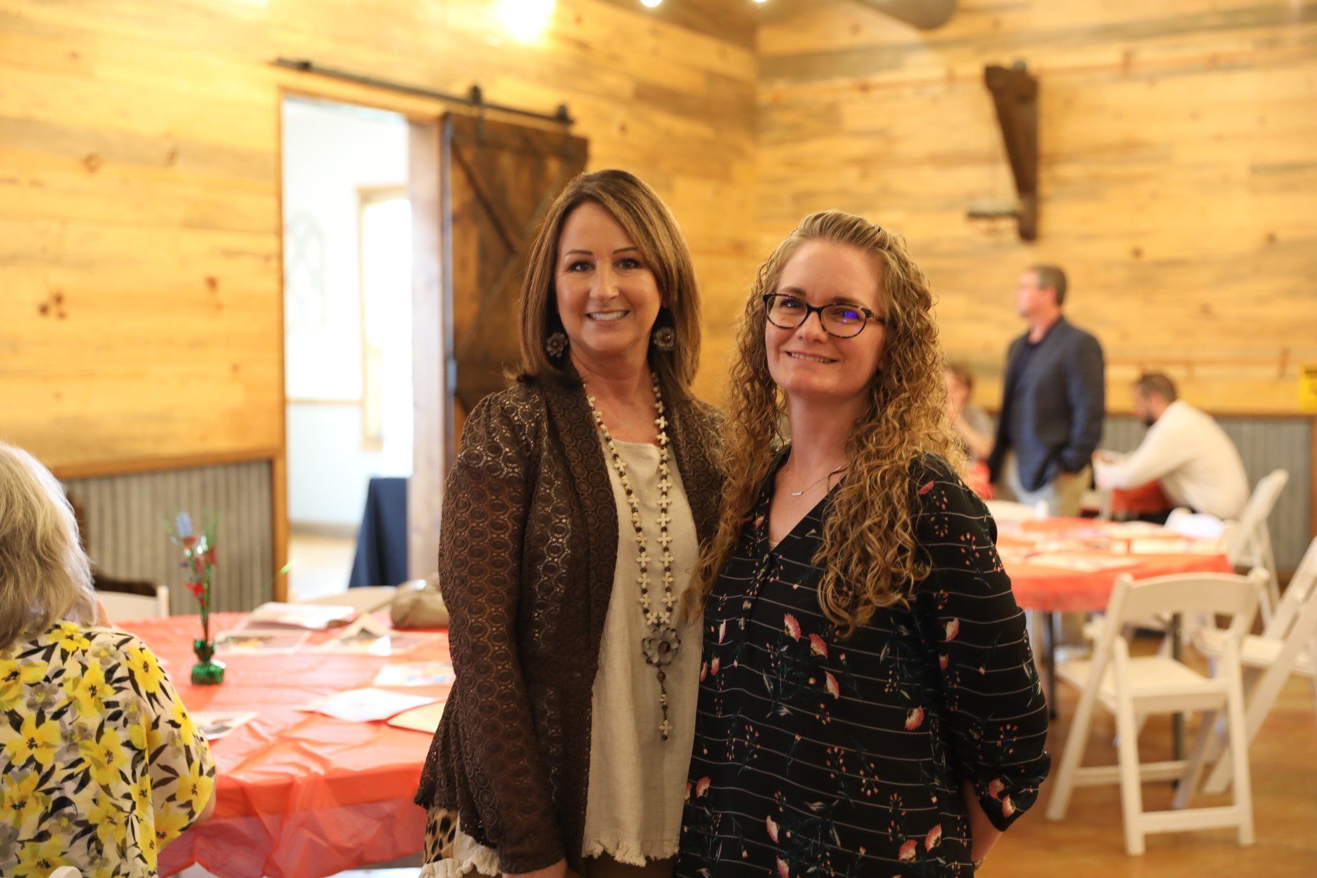 Two women are standing next to each other in a room.