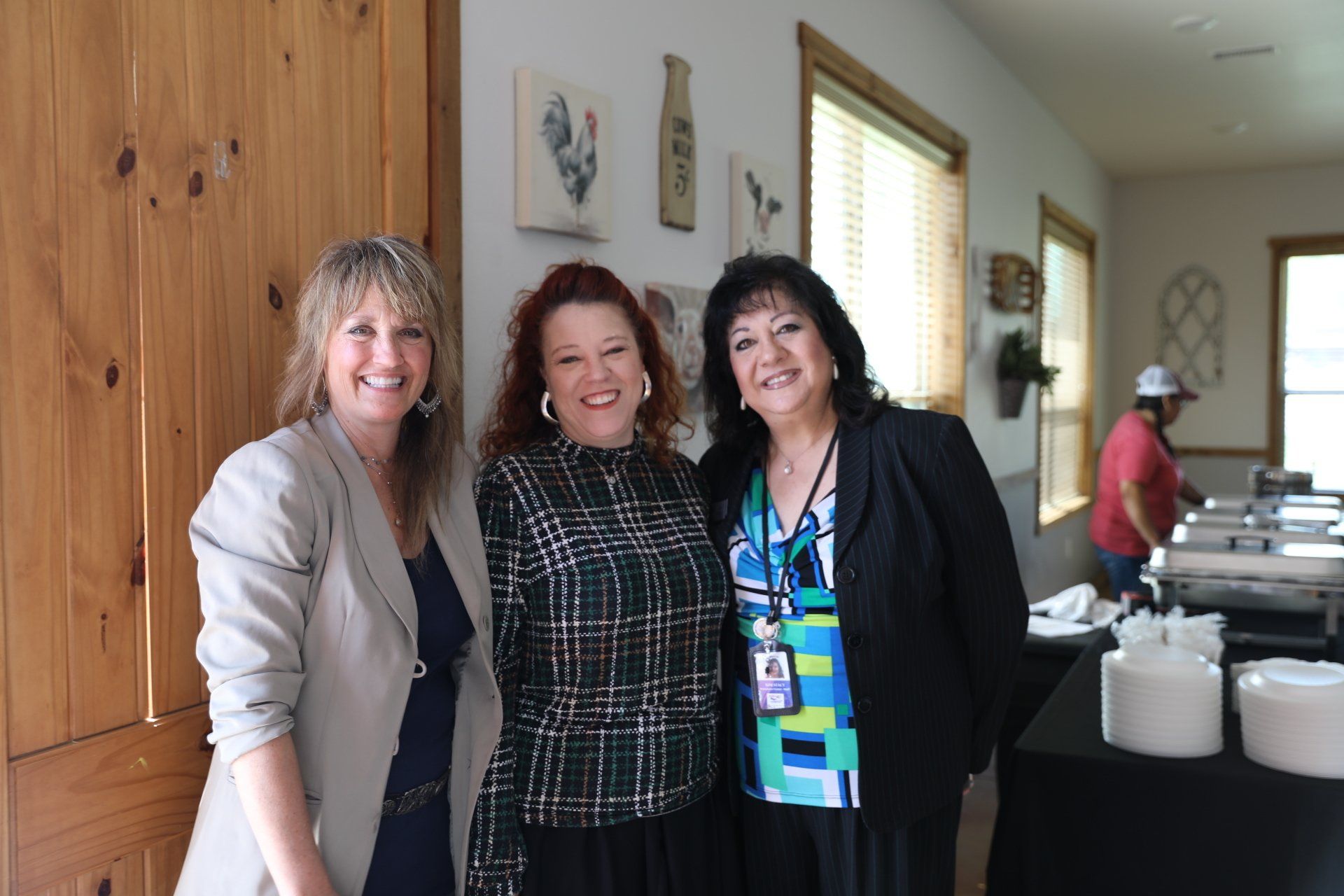 Three women are posing for a picture in a room.