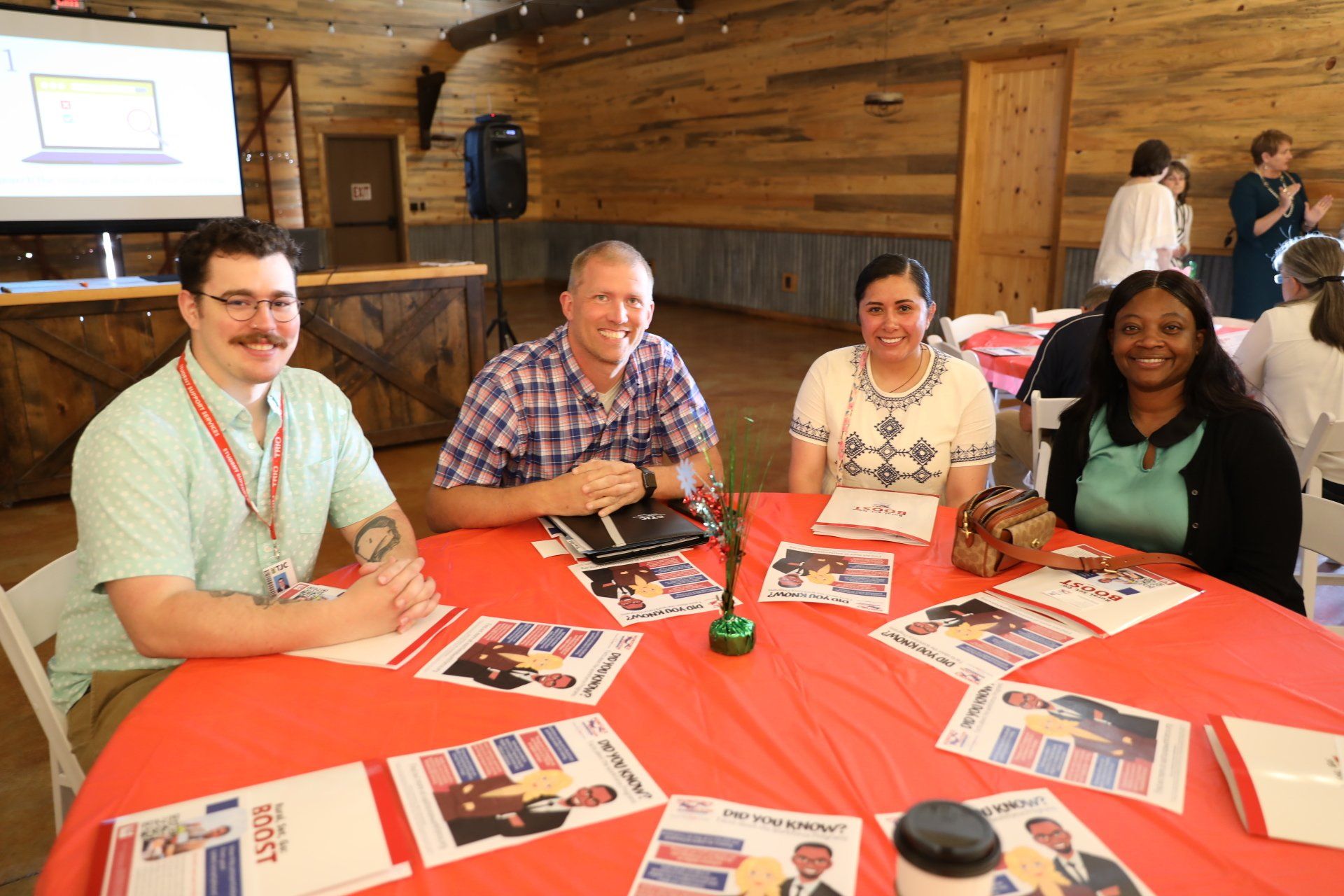 A group of people are sitting at a table with papers on it.
