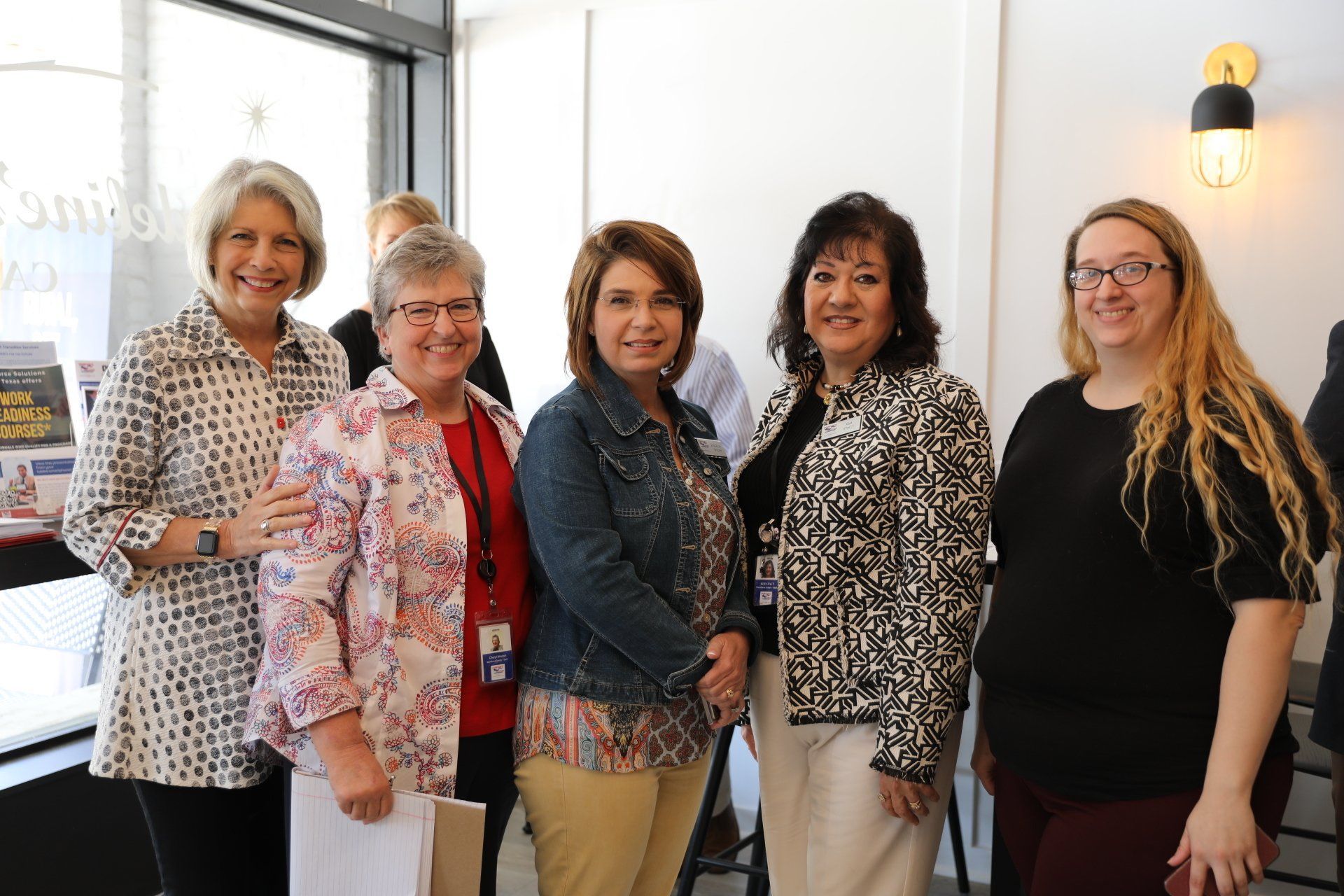 A group of women are posing for a picture together in a room.