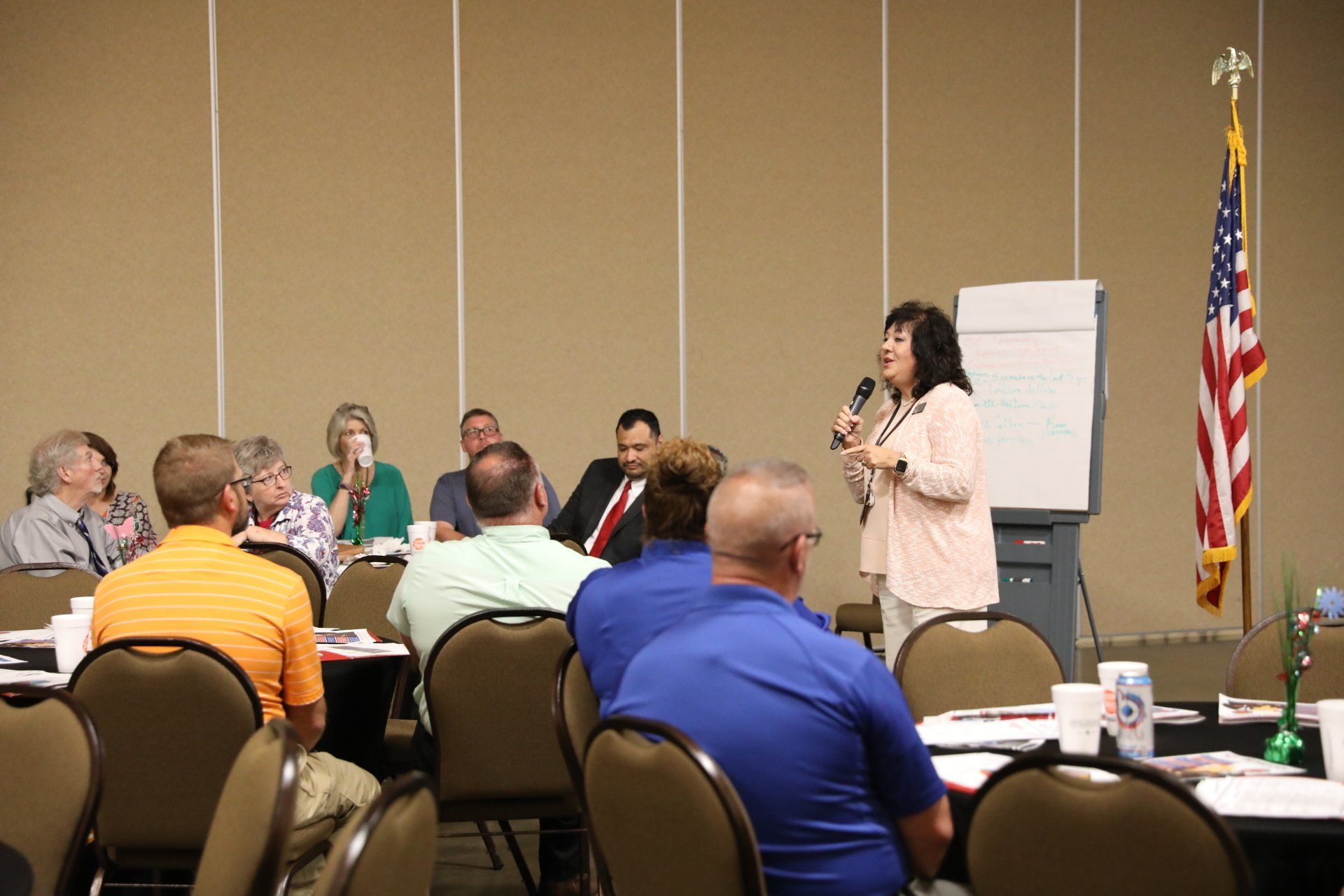 A woman is giving a presentation to a group of people in a conference room.