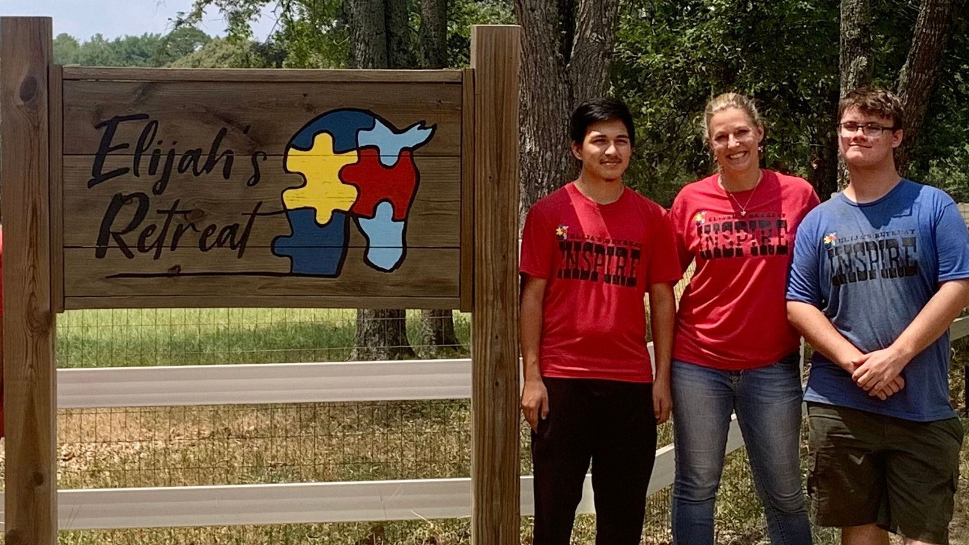A group of people standing in front of a sign that says elijah 's retreat
