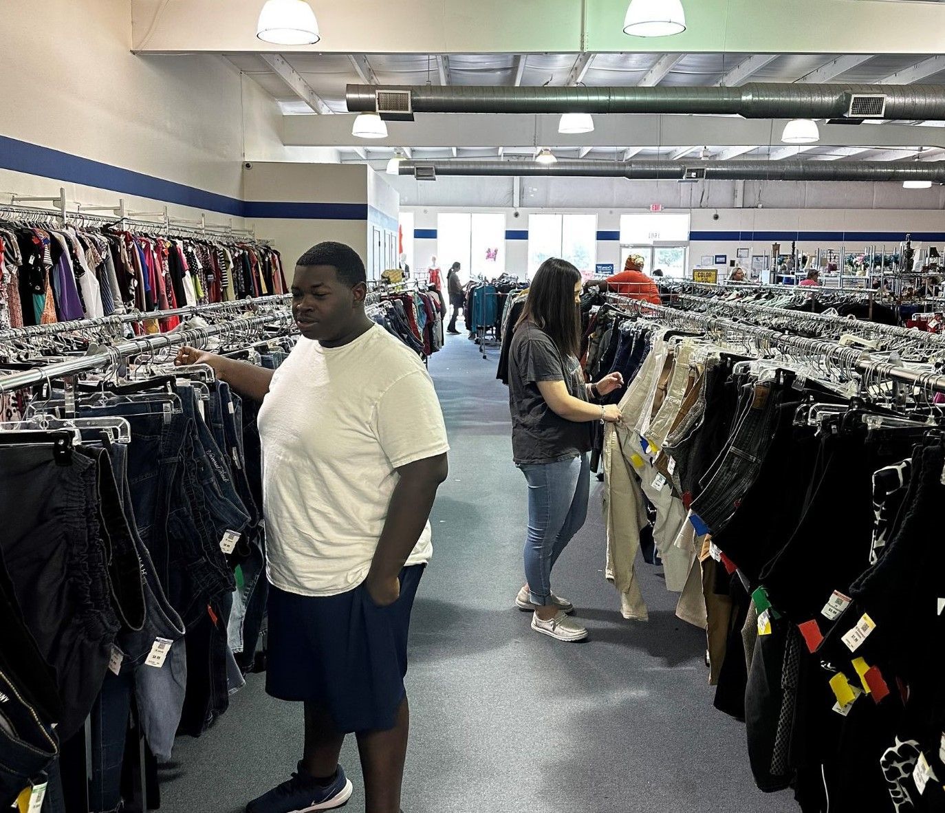 A man and a woman are shopping in a clothing store.