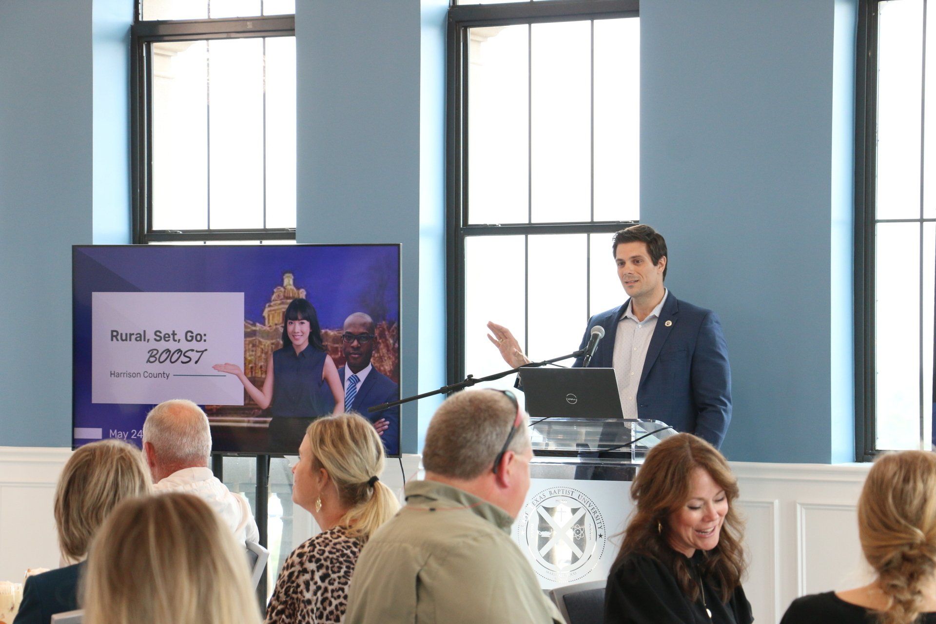 A man is standing at a podium giving a speech to a group of people.