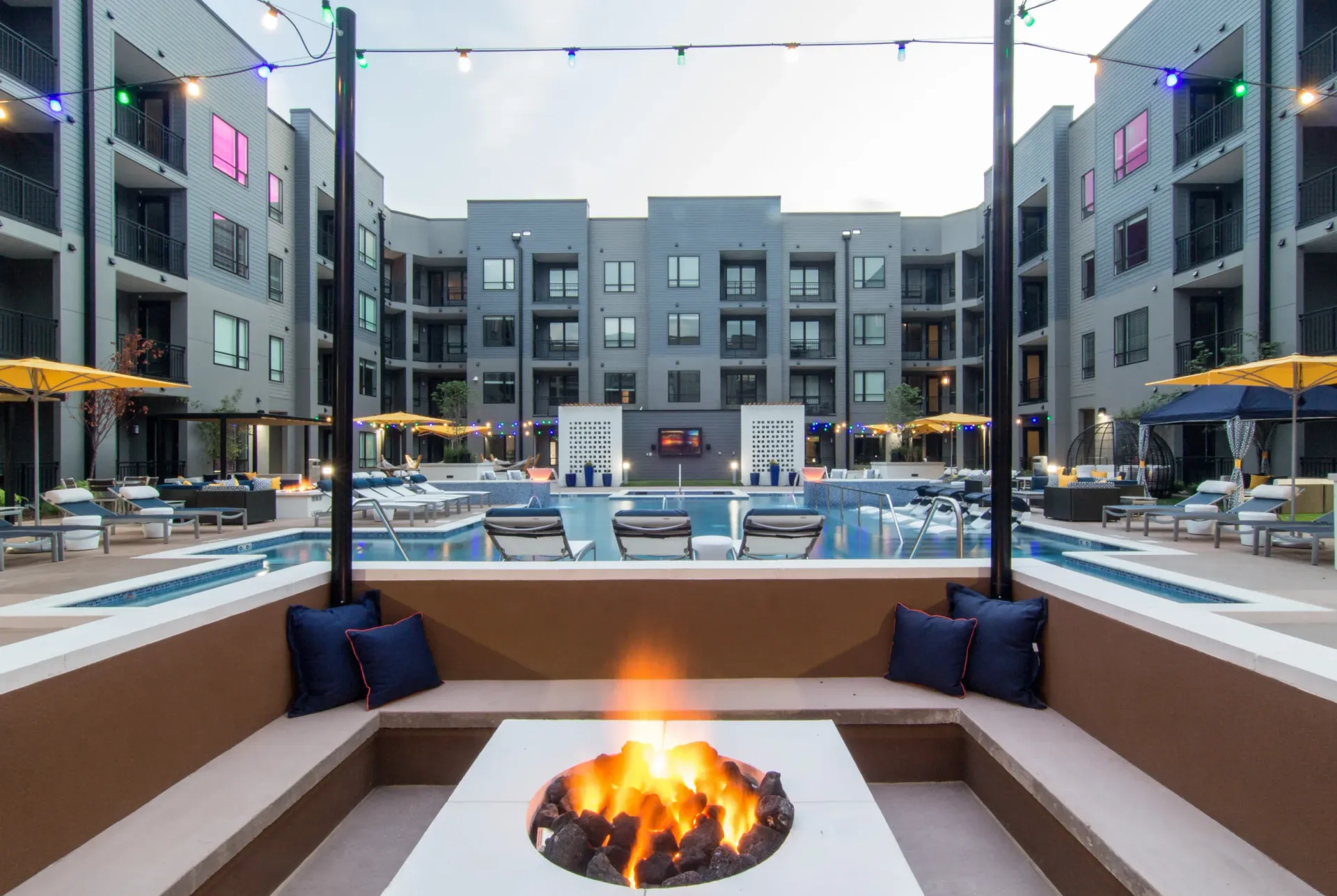 Outdoor pool courtyard with lounge seating and string lights at a modern apartment community at Chroma, offers apts for rent in St Louis.