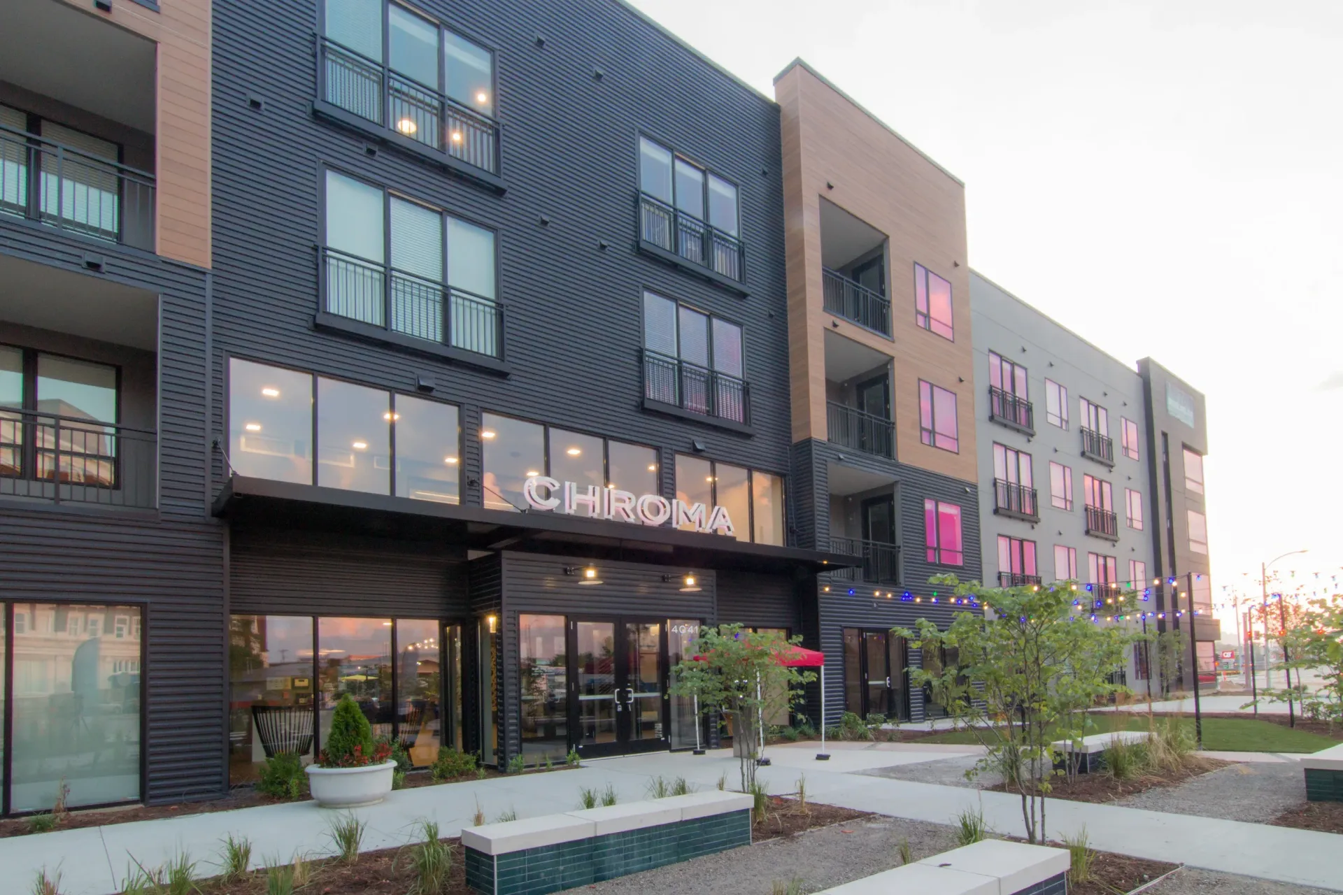 Exterior view of a modern multifamily building with balconies and a Chroma sign at Chroma apartments in The Grove in St. Louis, MO.