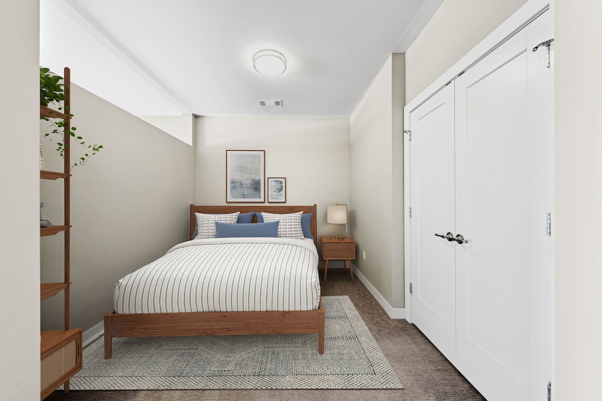 Cozy bedroom with a wooden bed, nightstand, lamp, and double white closet doors at Chroma, offers Saint Louis apartments for rent.