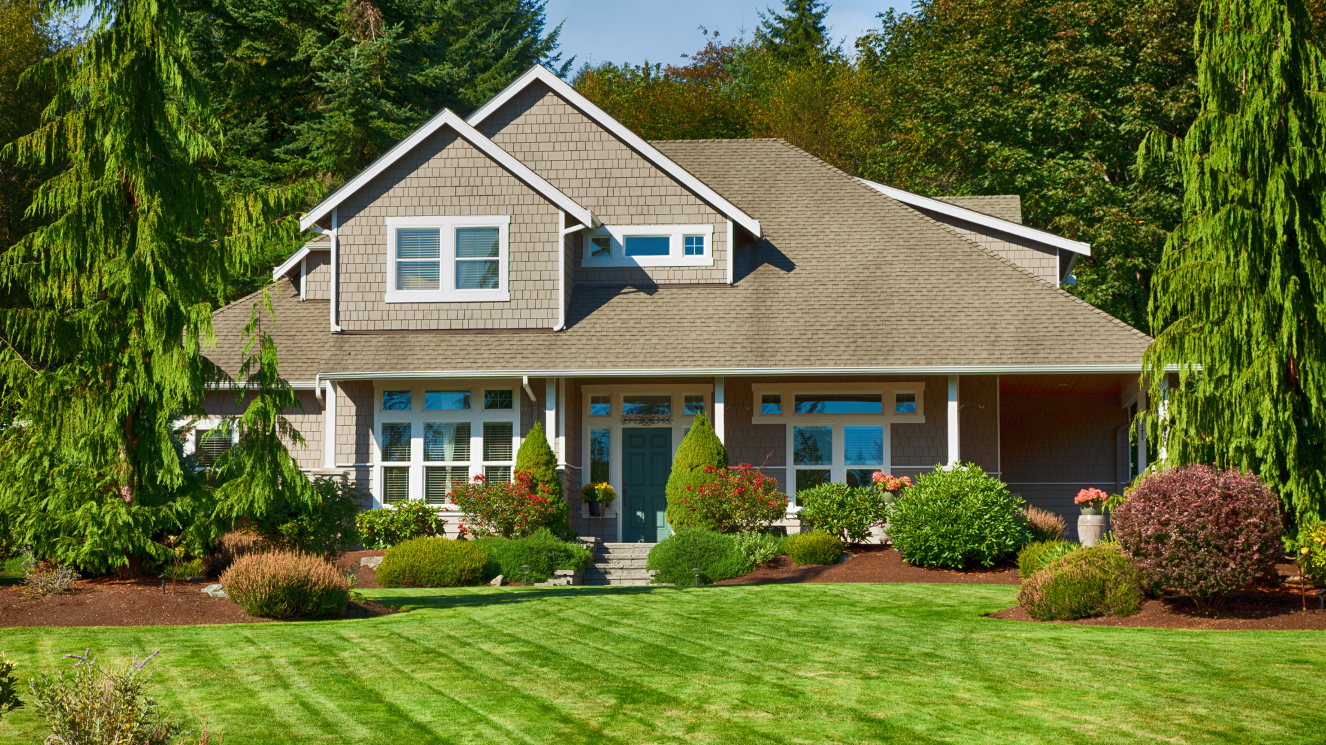 a large house with a lush green lawn in front of it