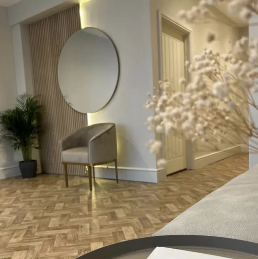 A living room with a couch a chair and a mirror