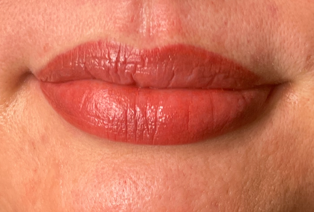 A close up of a woman 's lips with red lipstick.