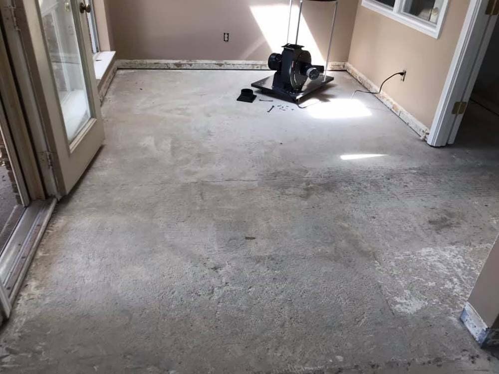 A room with a concrete floor and a fan on it.