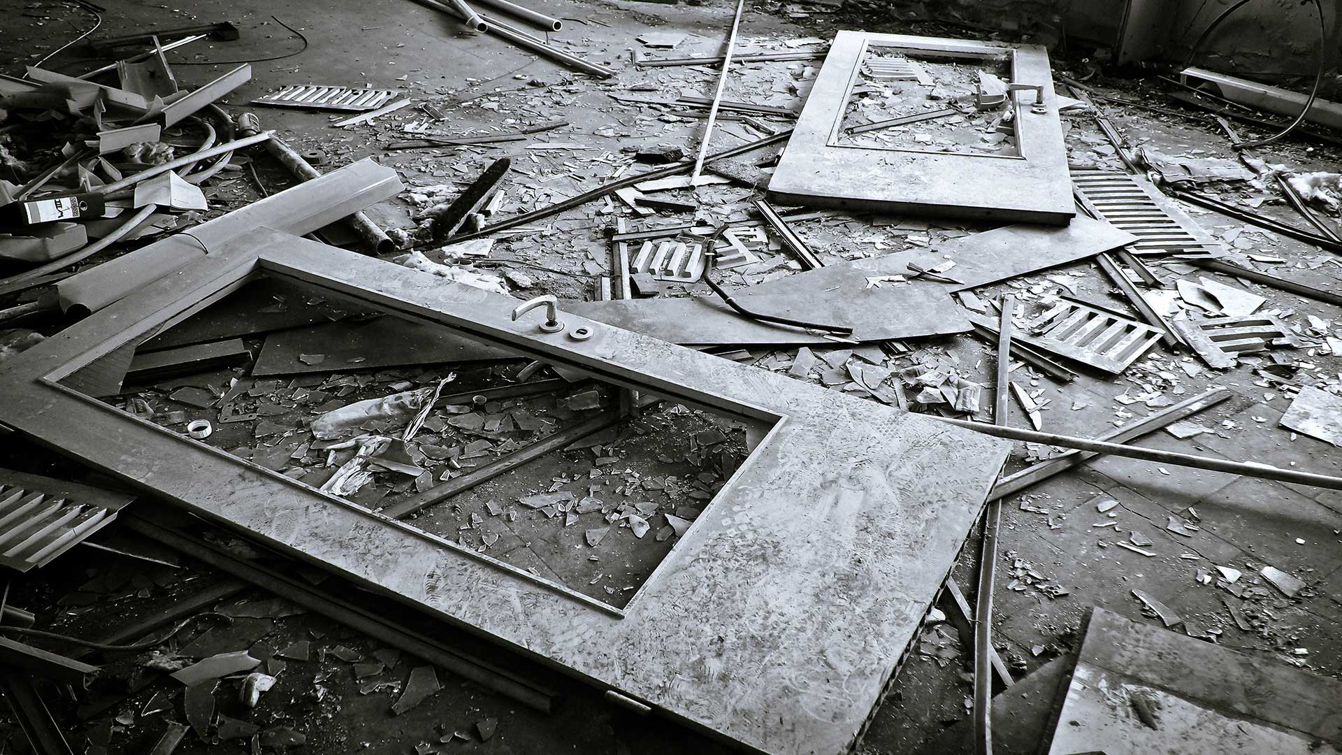 A black and white photo of a broken door on the floor.