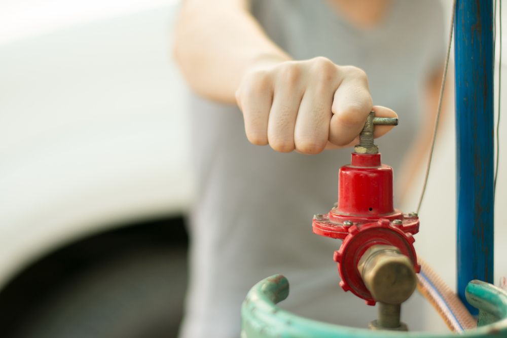 Gas Fitter Adjusting a Red Gas Valve