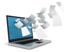 A laptop computer with papers flying out of it.