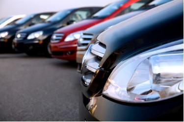 A row of cars are parked next to each other in a parking lot.