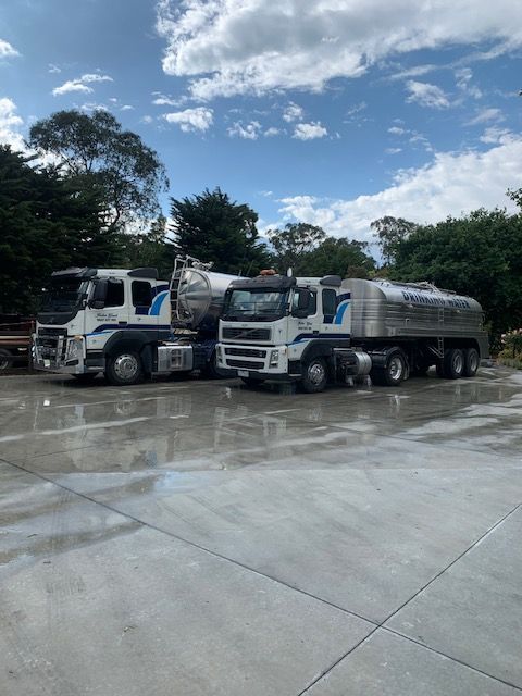 White water truck parked outdoors, viewed from the rear with ladders and large tanks visible.