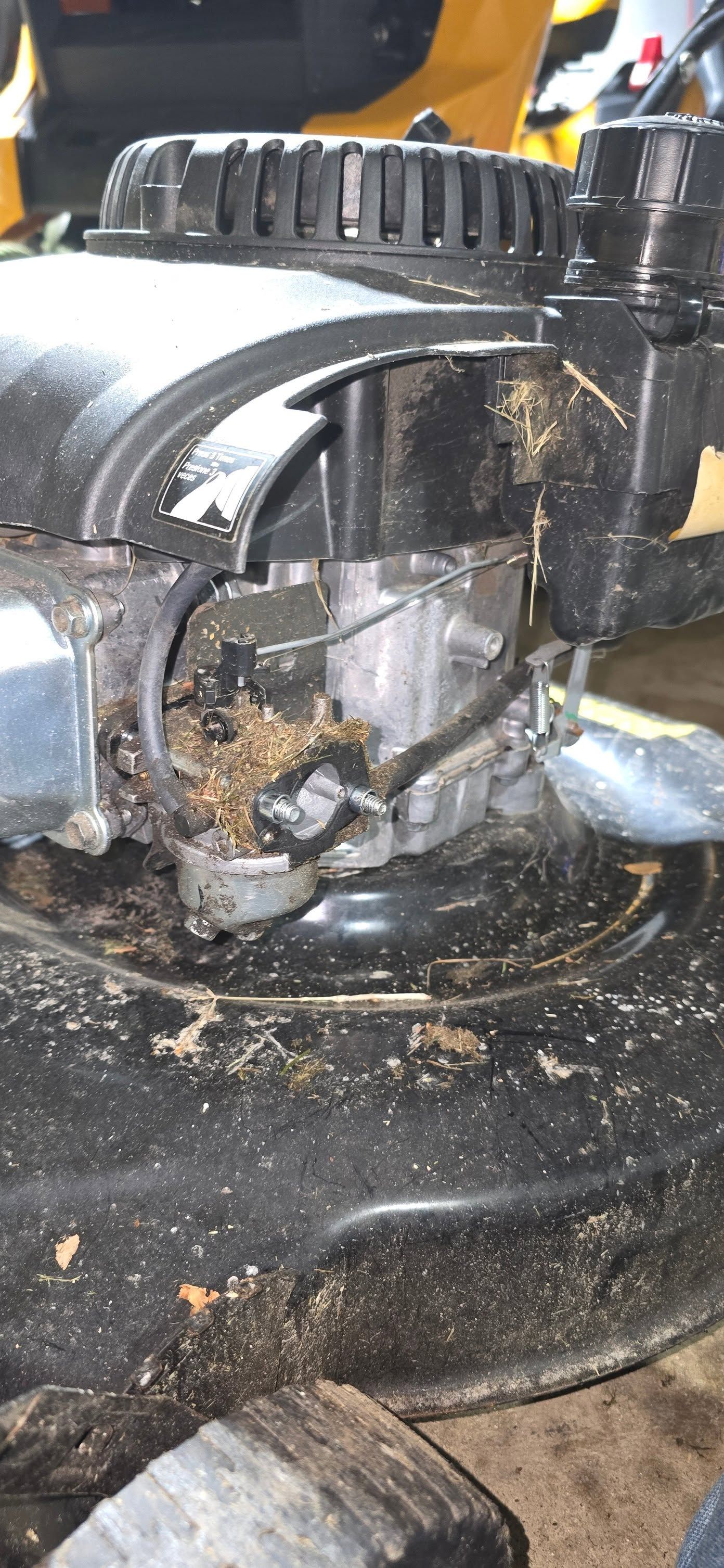 Close-up of a dirty, damaged machine part with black grease and a cracked circular housing