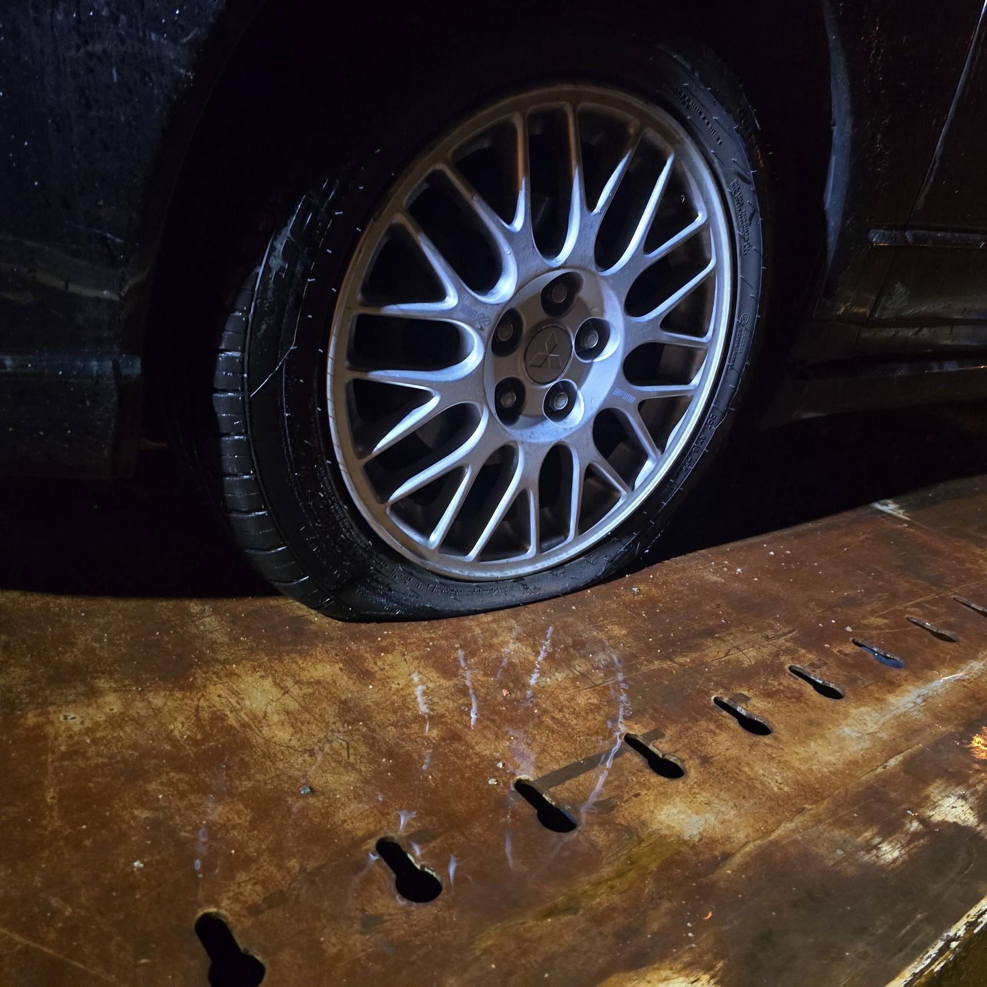 Car Tire on a Rusty Metal Surface, Nighttime Setting — Old Mate's Towing Townsville in Deeragun, QLD