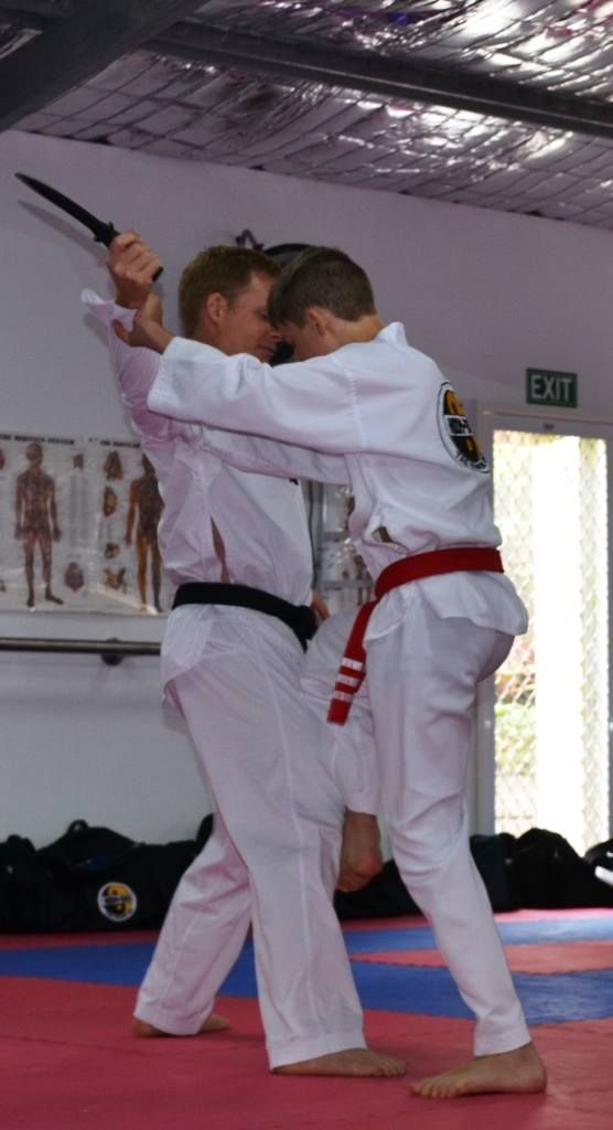 Two Men Are Practicing Martial Arts on a Mat in a Gym — Him-Do Tae Kwon Do Academy In Salamander Bay, NSW
