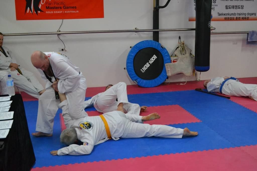A Group of People Are Practicing Take Downs in a Gym — Him-Do Tae Kwon Do Academy In Salamander Bay, NSW