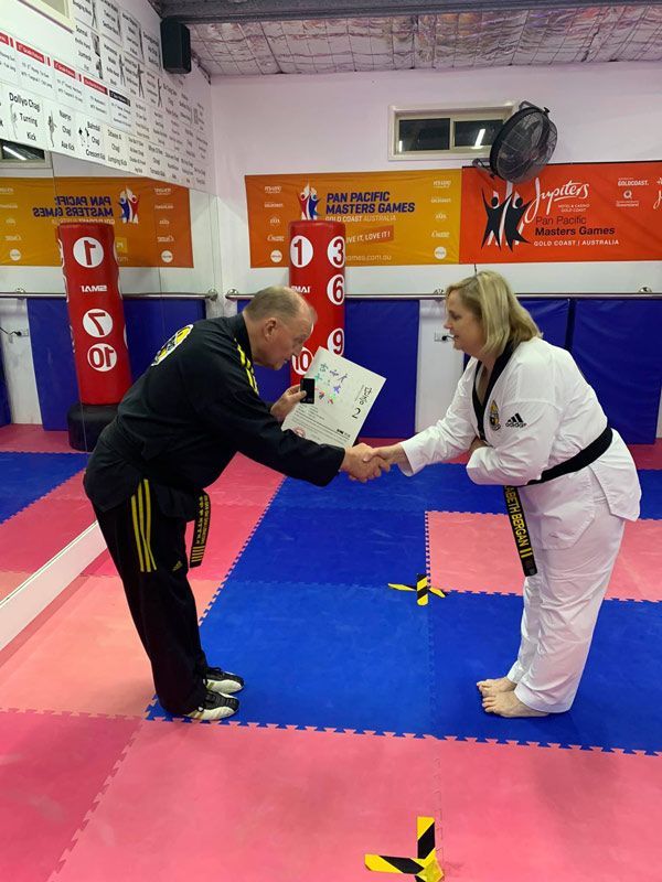 A Man and a Woman Are Shaking Hands in a Gym — Him-Do Tae Kwon Do Academy In Salamander Bay, NSW