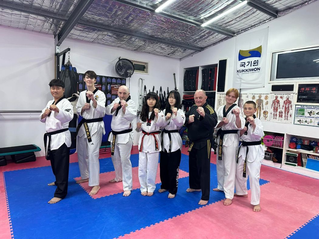 A Group of People in Uniforms Are Posing for a Picture in a Gym — Him-Do Tae Kwon Do Academy In Salamander Bay, NSW