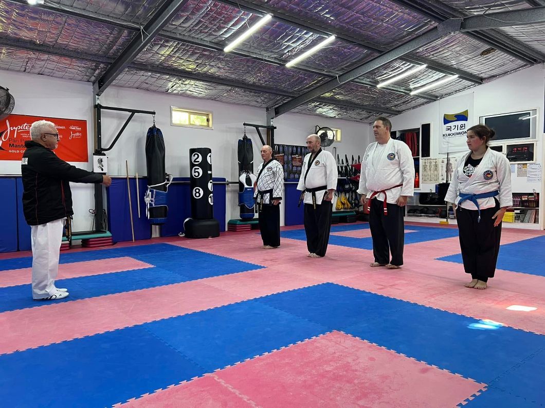 A Group of Men Are Standing on a Karate Mat in a Gym — Him-Do Tae Kwon Do Academy In Salamander Bay, NSW