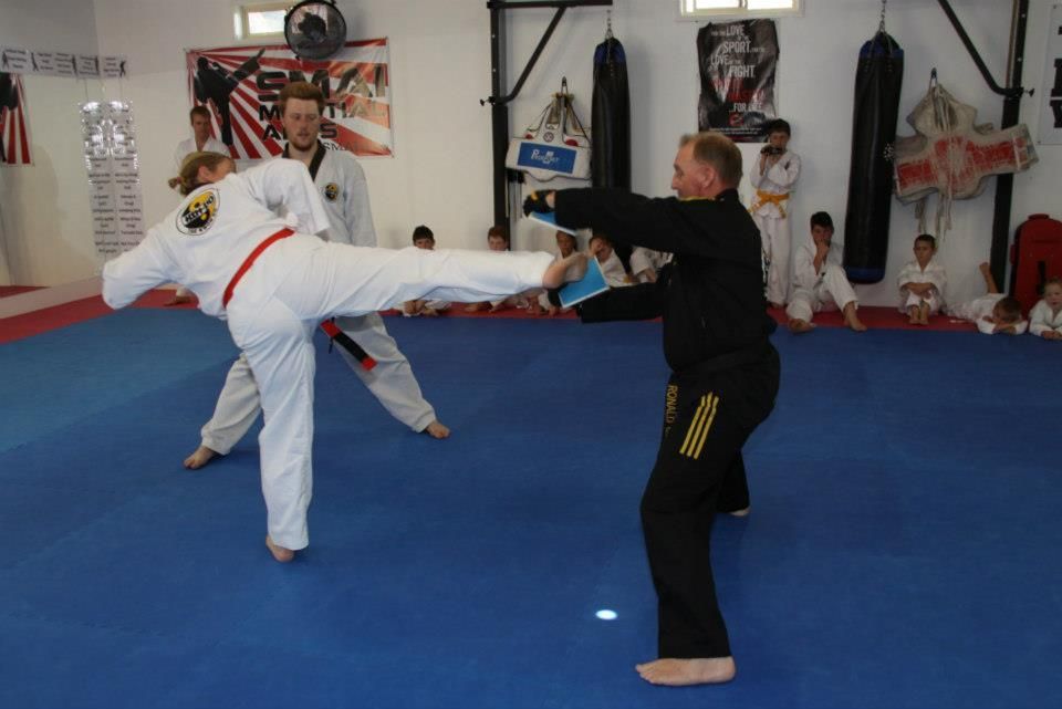 A Group of People Are Practicing Martial Arts on a Blue Mat — Him-Do Tae Kwon Do Academy In Salamander Bay, NSW