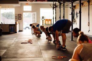 A group of people are doing squats in a gym.