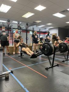 A group of people are using rowing machines in a gym.