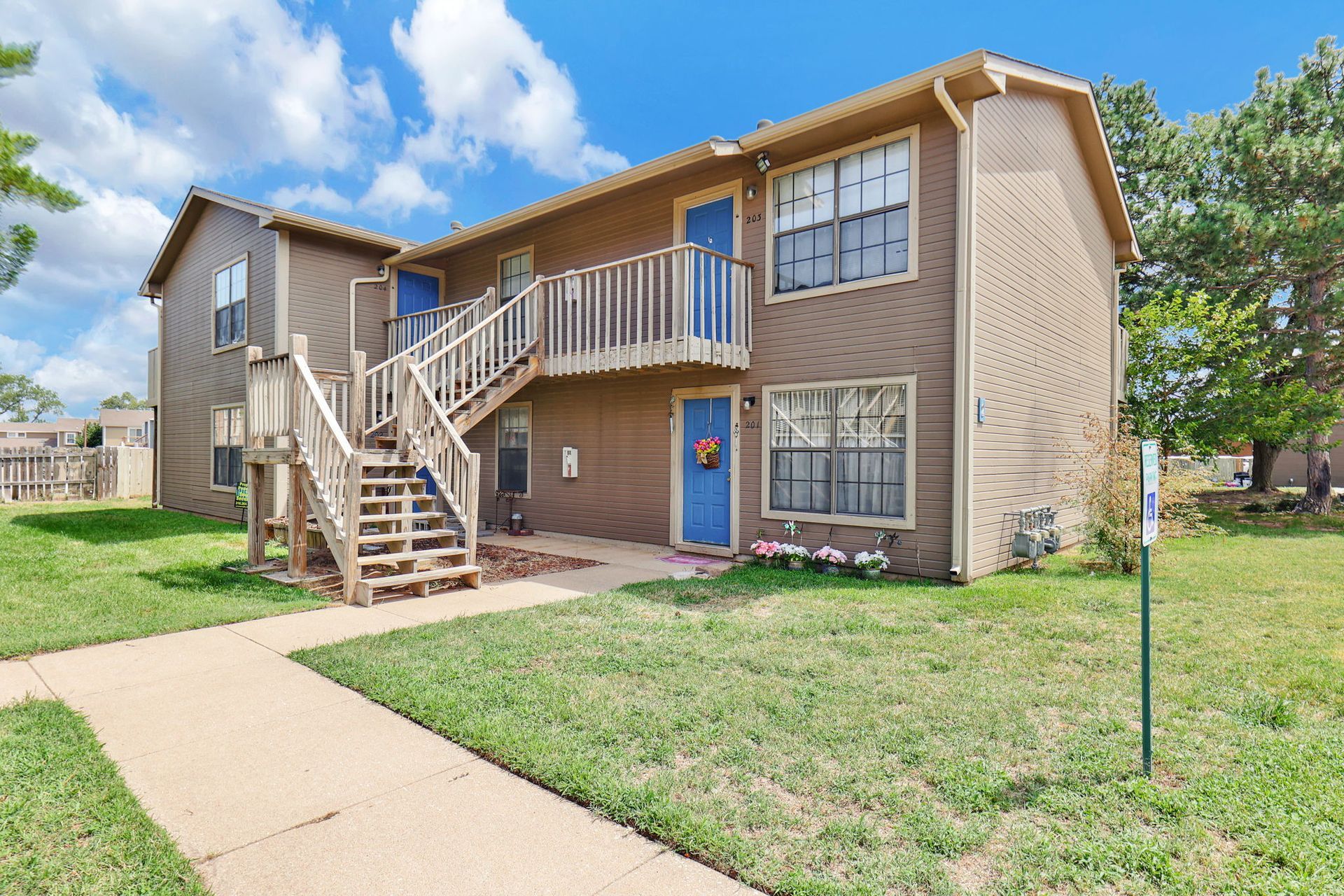 A large apartment building with stairs leading up to the second floor.