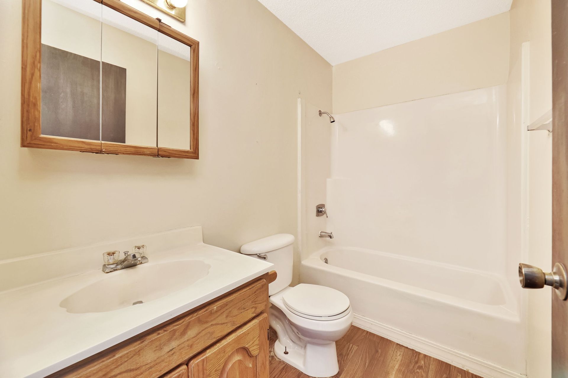 A bathroom with a toilet , sink , and bathtub.