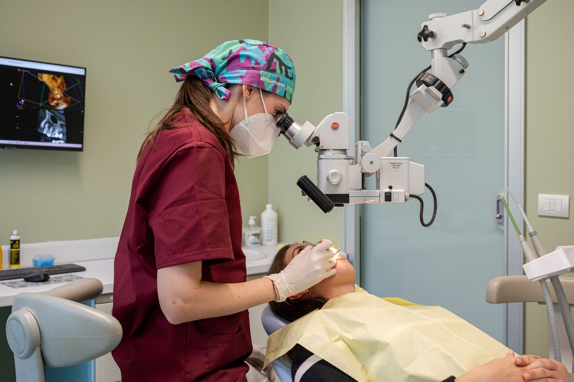 Dentista che usa il microscopio su un paziente in uno studio dentistico.