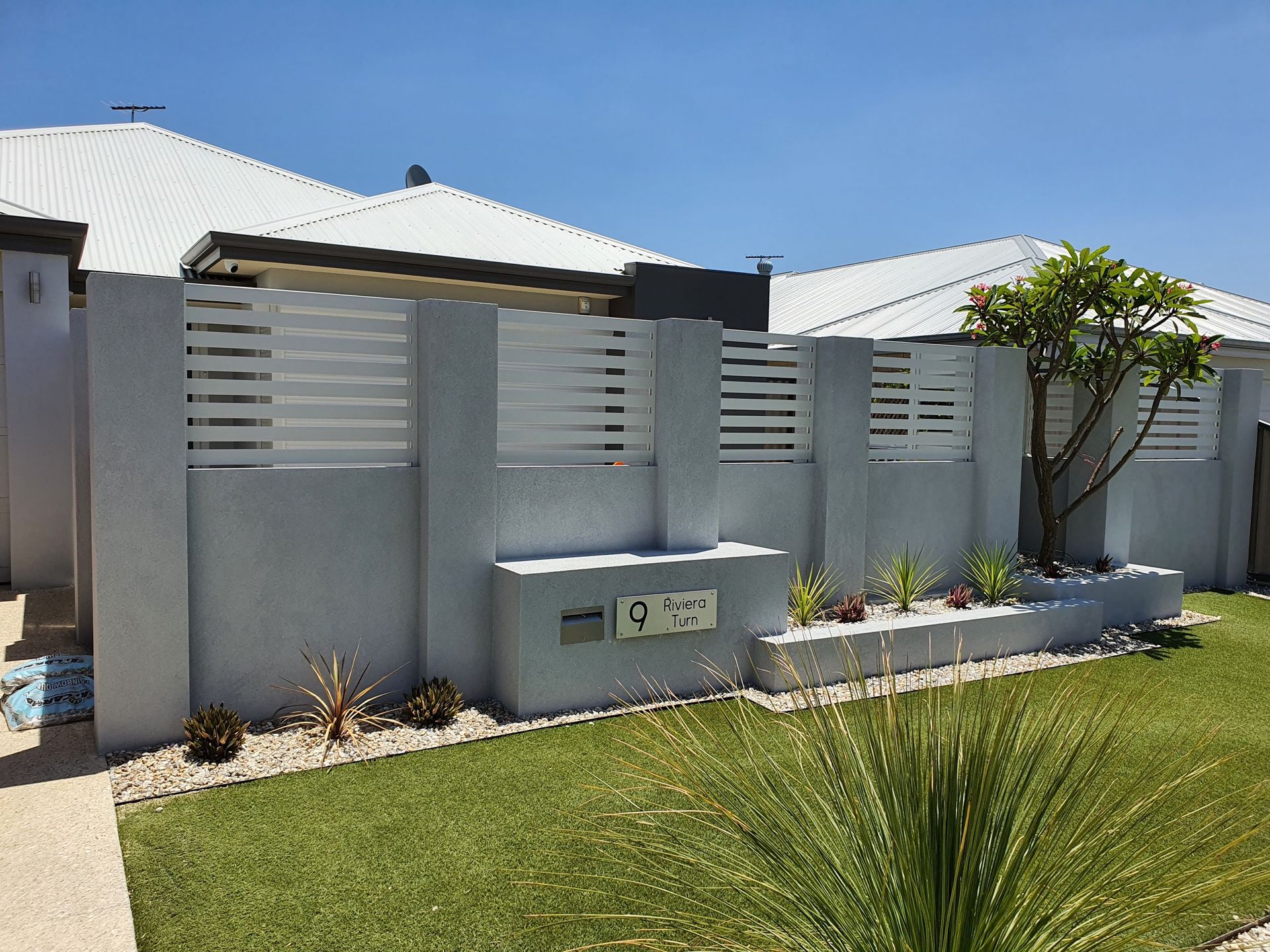 Boundary wall with aluminium slats build in Perth finished with grey texture coat.